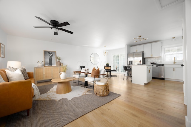 living room with light wood finished floors, ceiling fan, and a wealth of natural light