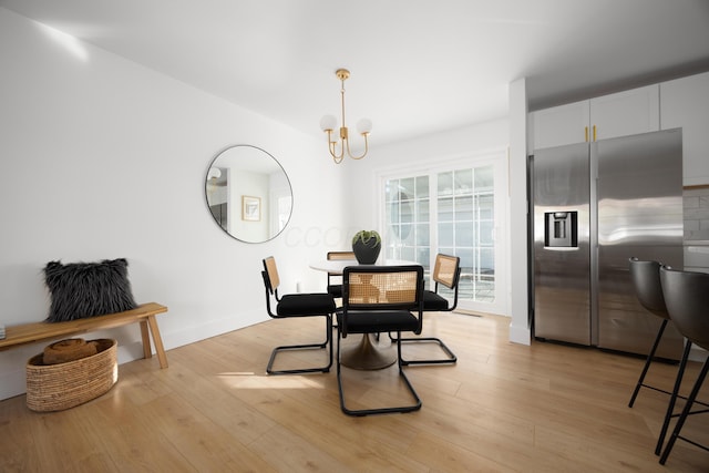 dining area with a chandelier and light wood-style flooring