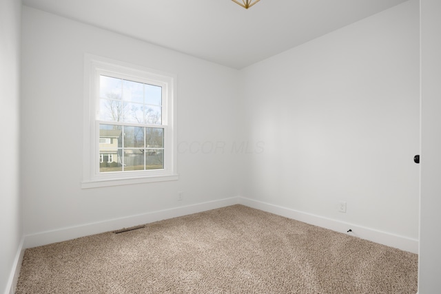 carpeted empty room with visible vents and baseboards