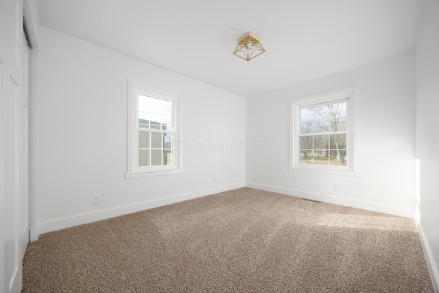 carpeted spare room with baseboards