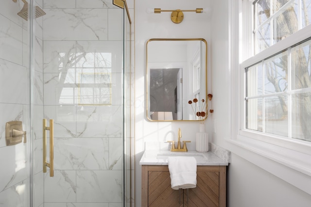 bathroom featuring a marble finish shower and vanity