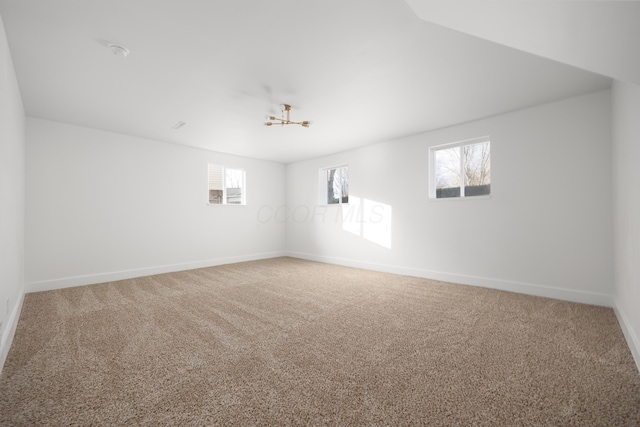 unfurnished room featuring carpet and baseboards