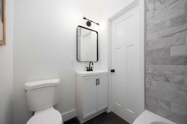 bathroom with toilet, visible vents, vanity, baseboards, and a bathtub