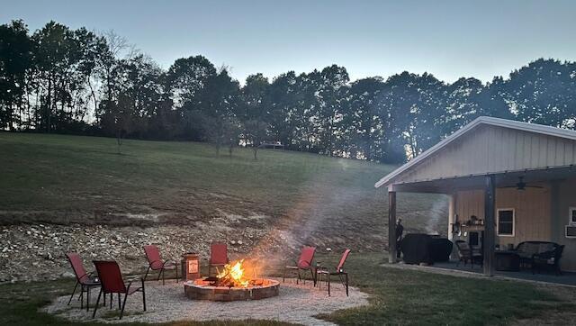 view of yard with a patio, an outdoor fire pit, and a ceiling fan