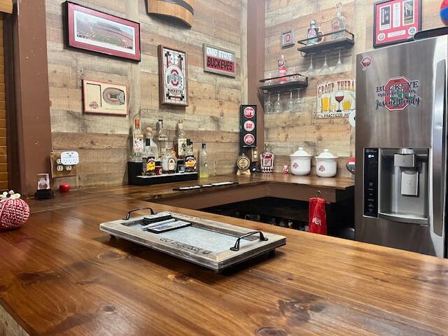 bar featuring a dry bar and stainless steel fridge with ice dispenser