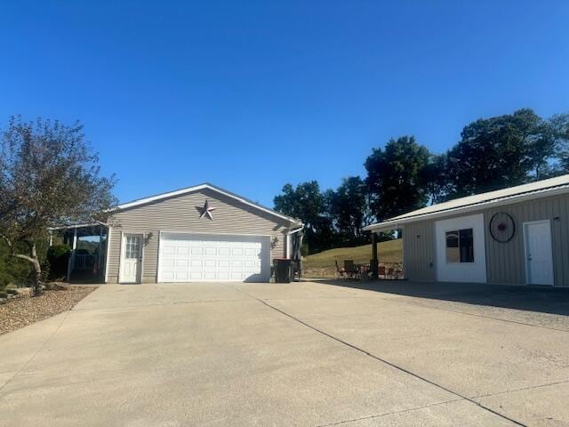 view of side of home featuring a garage and concrete driveway