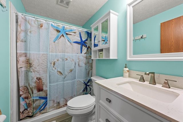 full bathroom featuring visible vents, a shower with shower curtain, toilet, a textured ceiling, and vanity