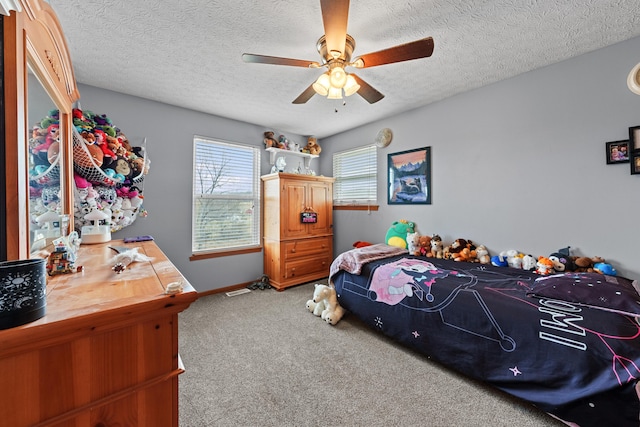 bedroom featuring carpet floors, a textured ceiling, baseboards, and a ceiling fan