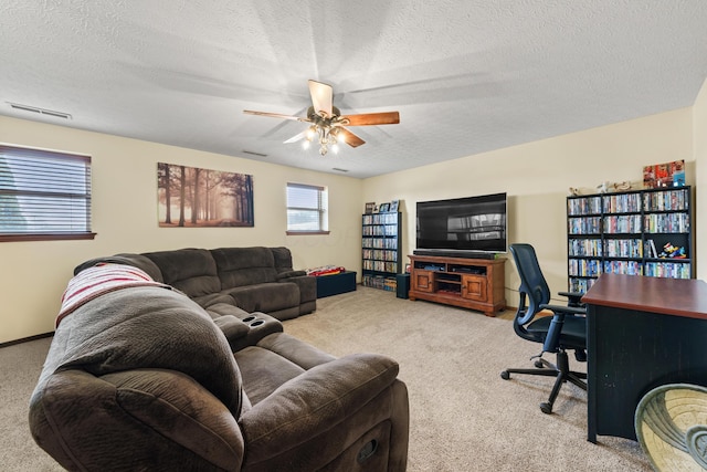 living area with a ceiling fan, a textured ceiling, visible vents, and carpet flooring