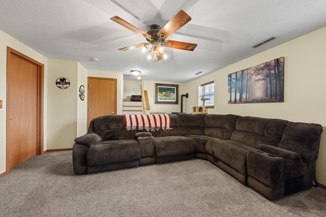 carpeted living area with a ceiling fan, baseboards, visible vents, and a textured ceiling