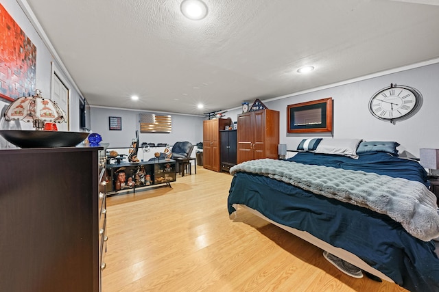 bedroom with a textured ceiling, ornamental molding, recessed lighting, and light wood-style floors