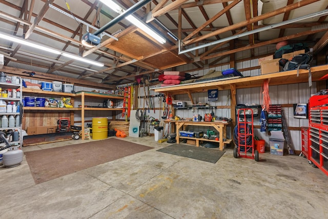 garage with a garage door opener, a workshop area, and metal wall