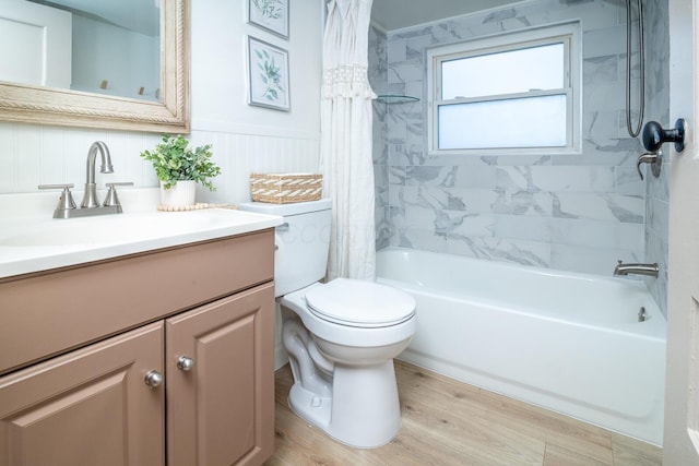 bathroom with toilet, a wainscoted wall, wood finished floors, shower / bathtub combination with curtain, and vanity