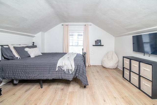 bedroom with lofted ceiling and wood finished floors