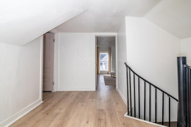 additional living space with lofted ceiling, light wood-style floors, and baseboards