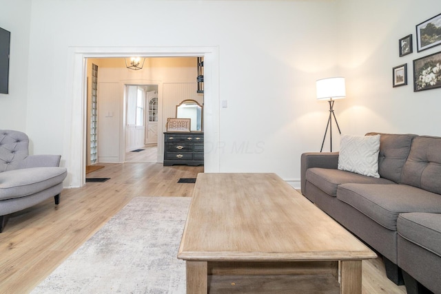 living area with light wood-type flooring and a chandelier