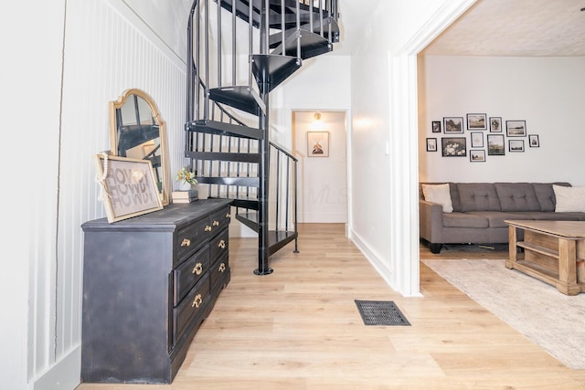 staircase with visible vents, baseboards, and wood finished floors