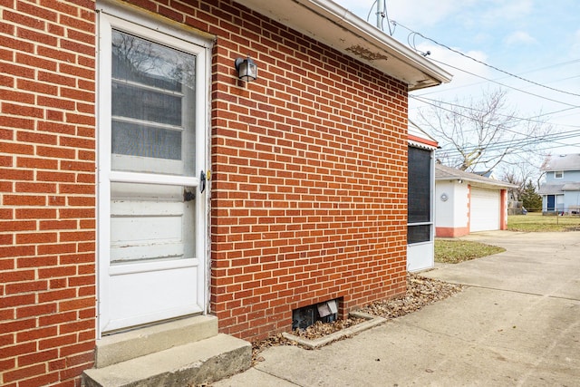 view of home's exterior featuring entry steps, driveway, and brick siding