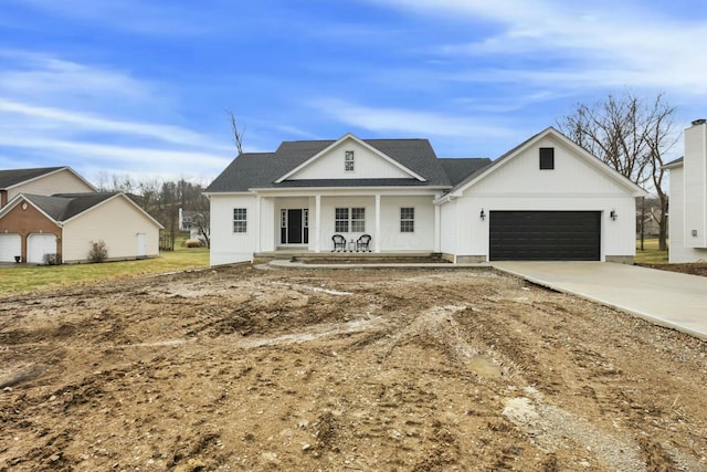 view of front of property featuring a porch, concrete driveway, and a garage