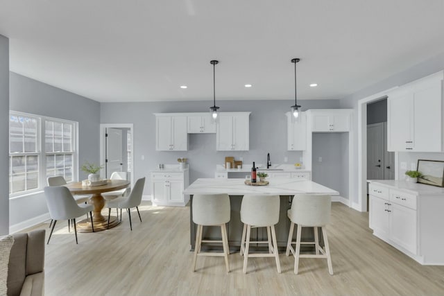 kitchen featuring light wood-type flooring, white cabinets, and a center island