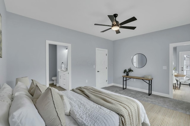 carpeted bedroom with a ceiling fan, baseboards, and ensuite bathroom