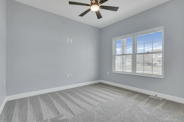 spare room featuring a ceiling fan, carpet, visible vents, and baseboards