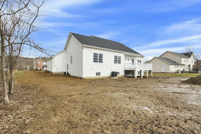 back of property featuring central AC and roof with shingles