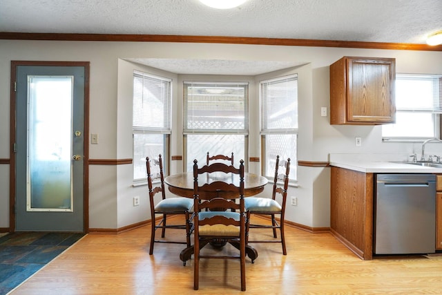 dining area featuring a textured ceiling, light wood finished floors, and baseboards