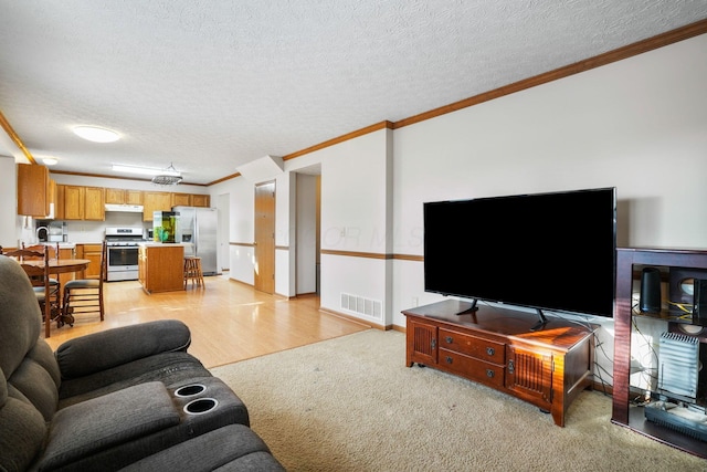 living area with crown molding, visible vents, light carpet, a textured ceiling, and baseboards