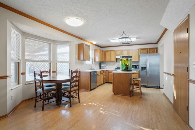 kitchen featuring light countertops, appliances with stainless steel finishes, a sink, and light wood-style flooring