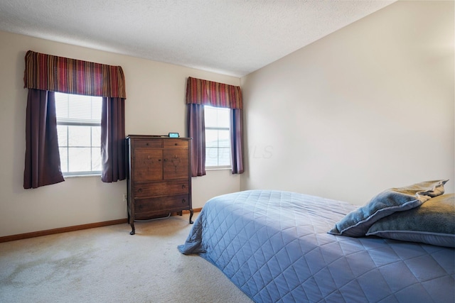 carpeted bedroom with multiple windows, a textured ceiling, and baseboards