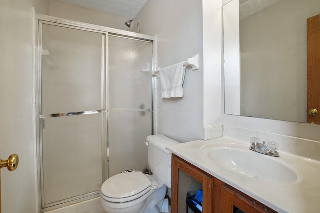 full bathroom with toilet, a shower stall, a textured ceiling, and vanity