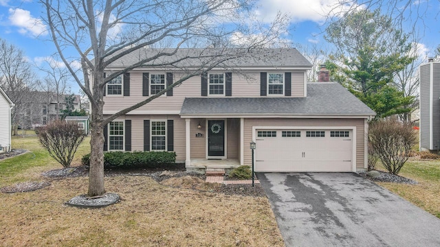 view of front facade featuring aphalt driveway, a chimney, a shingled roof, and a front yard