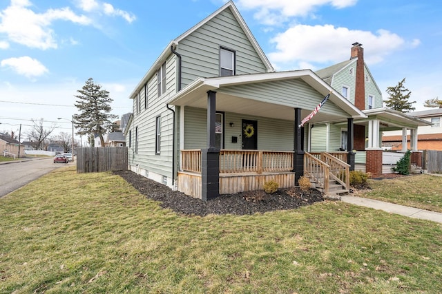 view of front of home featuring fence, a front lawn, and a porch