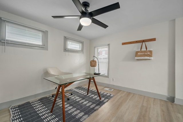 office featuring a ceiling fan, baseboards, visible vents, and wood finished floors