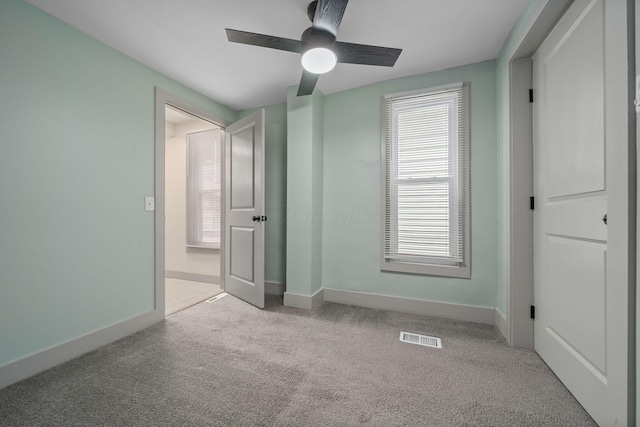 unfurnished bedroom with a ceiling fan, carpet flooring, visible vents, and baseboards