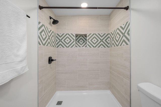 full bathroom featuring toilet and a tile shower