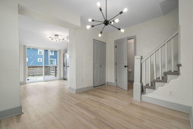 interior space with floor to ceiling windows, light wood-style flooring, stairway, a chandelier, and baseboards