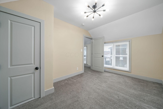 unfurnished bedroom with carpet, vaulted ceiling, baseboards, and an inviting chandelier