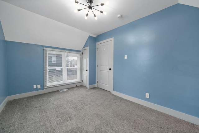 additional living space with carpet floors, visible vents, vaulted ceiling, and baseboards