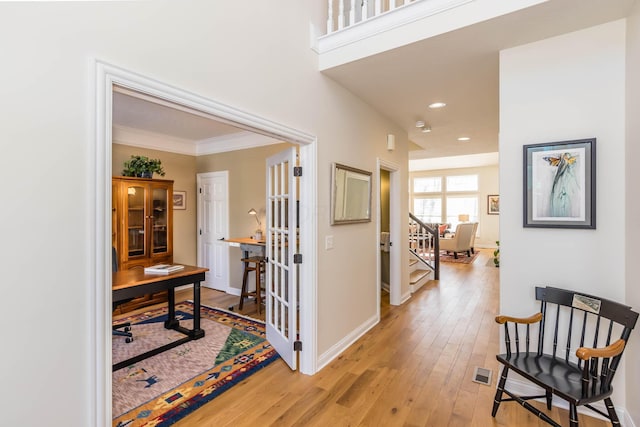 corridor with crown molding, recessed lighting, visible vents, light wood-style floors, and baseboards