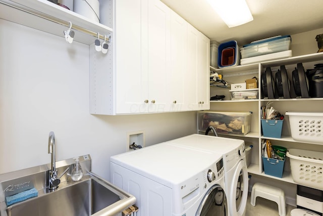 laundry area with cabinet space, a sink, and washing machine and clothes dryer