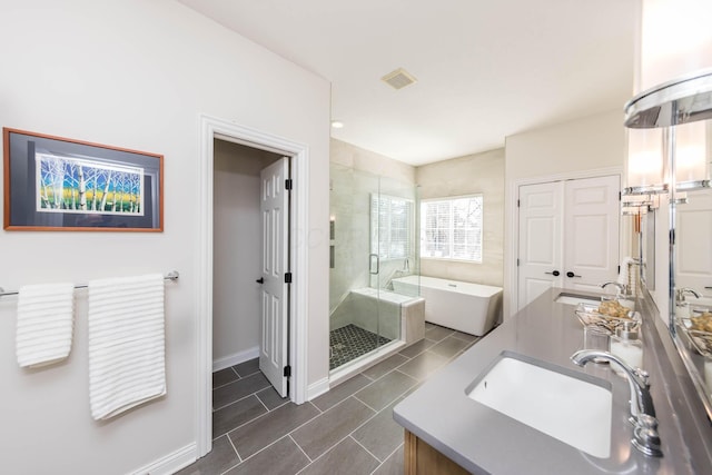 full bath featuring a freestanding bath, a sink, visible vents, and a shower stall