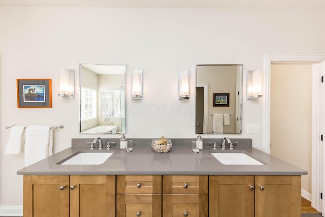 bathroom with a tub to relax in, a sink, and double vanity