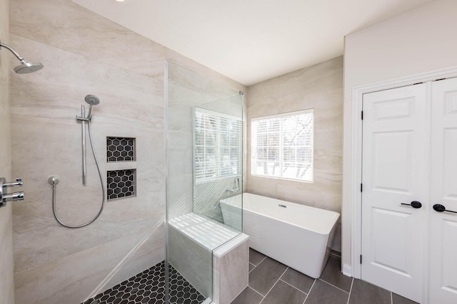 full bath featuring tiled shower, a soaking tub, and tile patterned floors