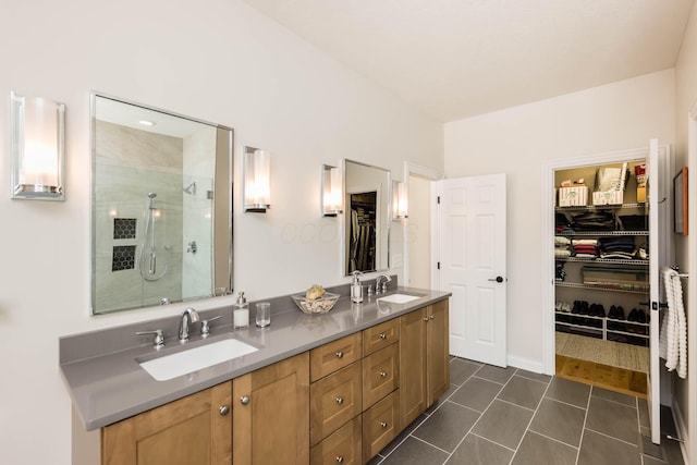 full bath featuring tile patterned flooring, a shower stall, a walk in closet, and a sink