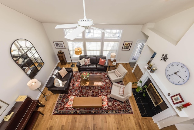 living area with ceiling fan, baseboards, and wood finished floors