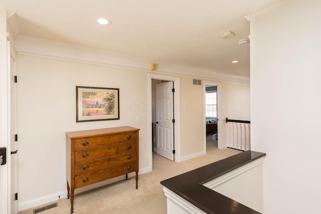 hall featuring light carpet, visible vents, and ornamental molding