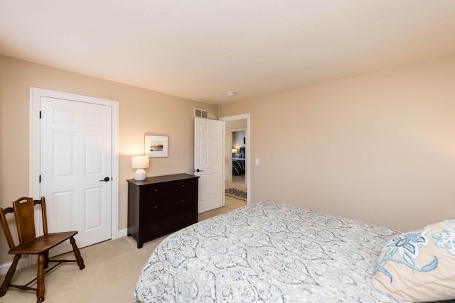 bedroom featuring visible vents, light carpet, and baseboards