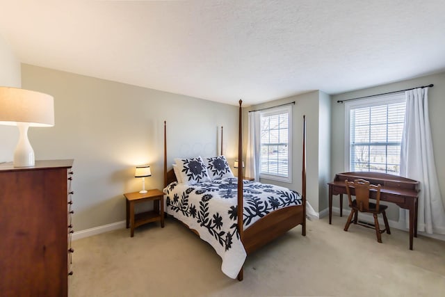 bedroom with light carpet, a textured ceiling, and baseboards